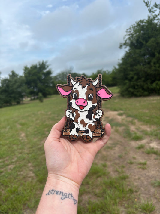 Cow print swinging cow